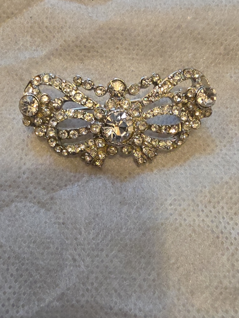 VIntage, silver-tone crystal rhinestone brooch with an ornate bow or wing-like f